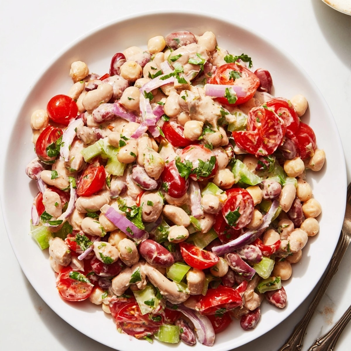 Delicious Creamy Bean Salad recipe: colorful beans and veggies tossed in tangy dressing.