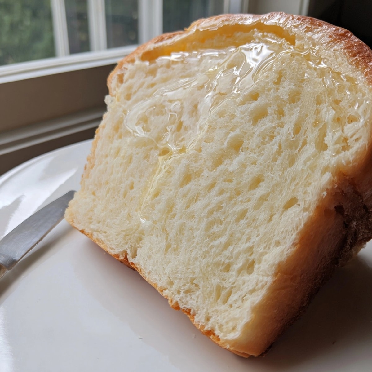 Warm, soft slices of Homemade Buttery White Bread with visible air pockets throughout the crumb.