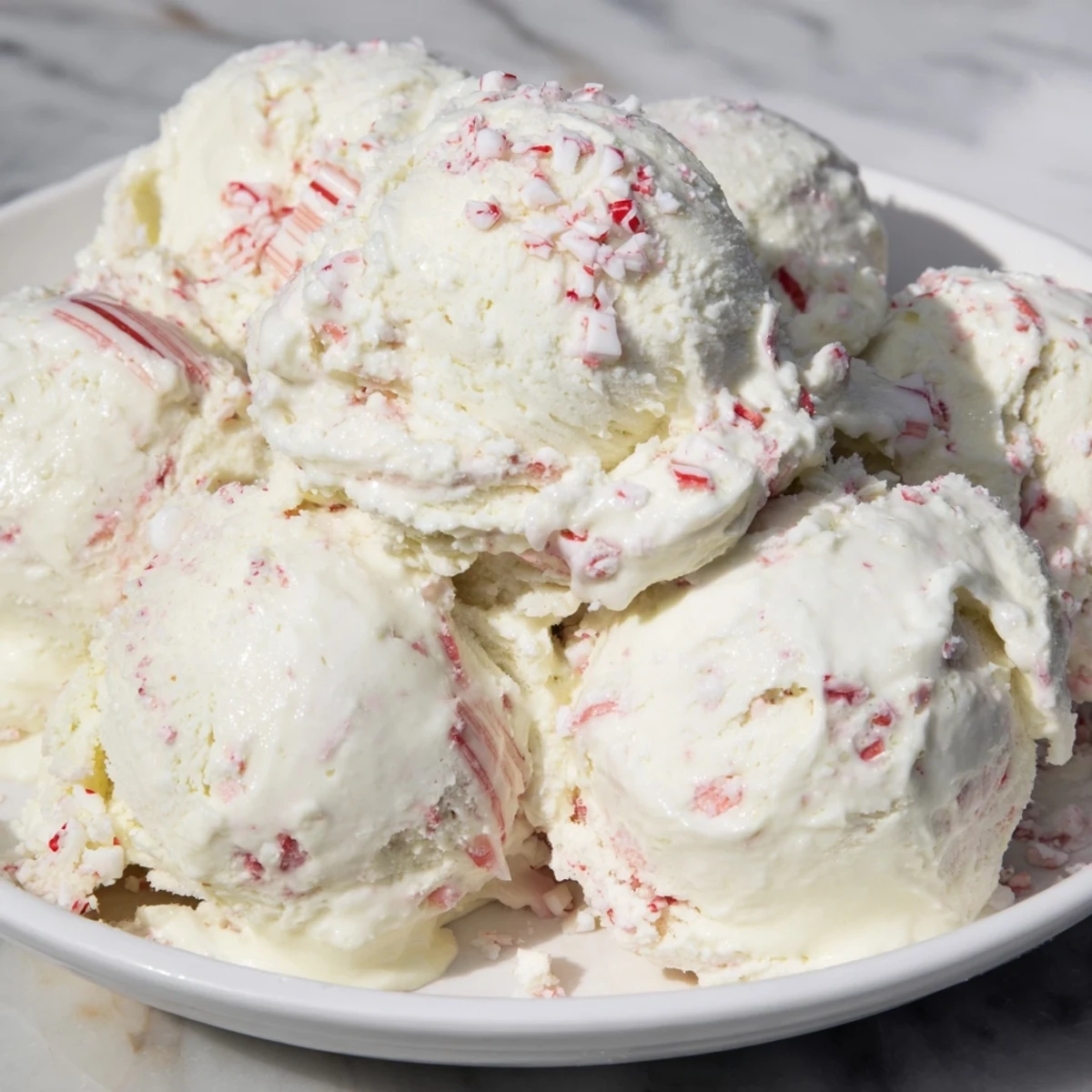 A scoop of homemade Peppermint Ice Cream, swirled with crushed candy and ready to enjoy.