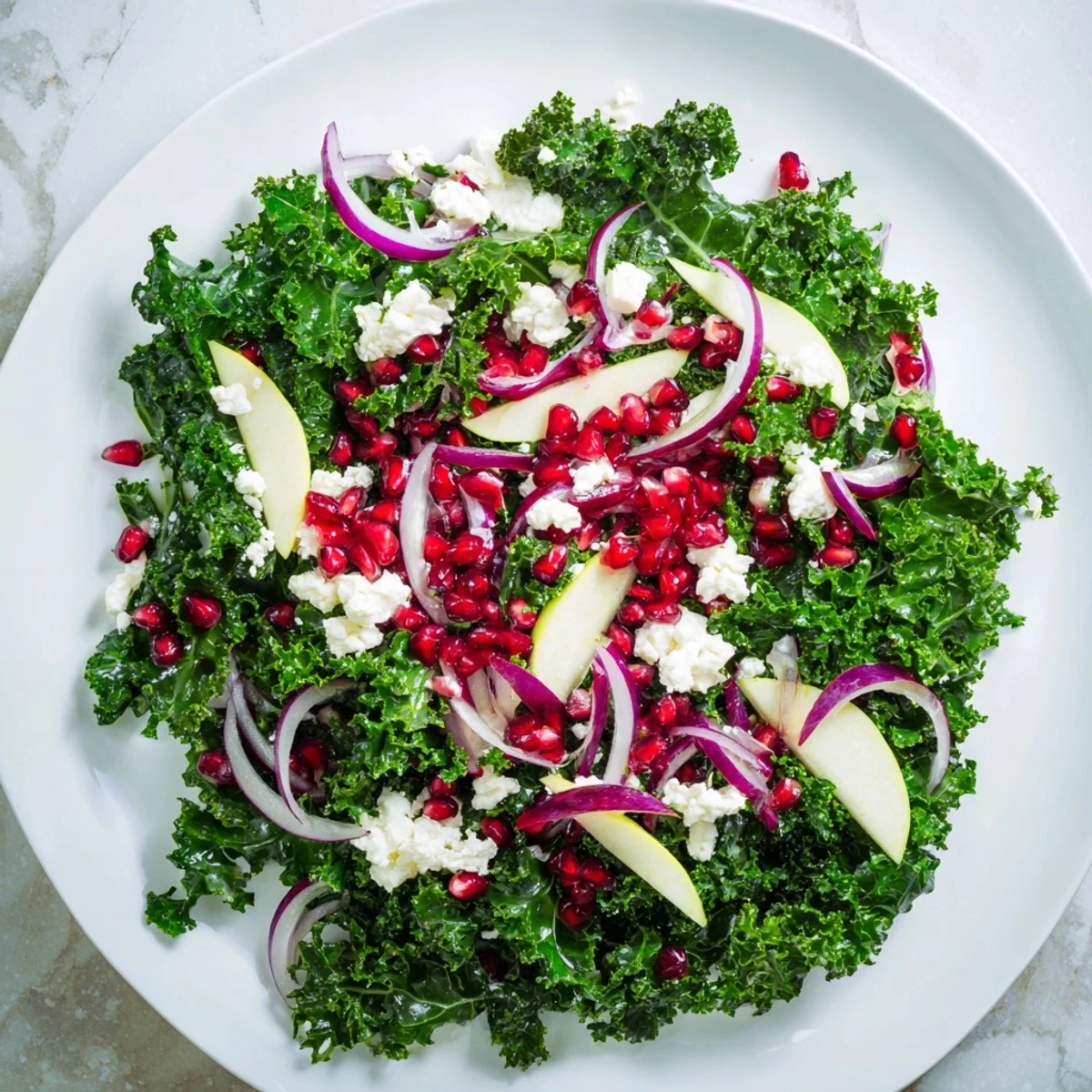 This delicious Winter Kale Salad with Pomegranate features a colorful mix of greens and a bright citrus dressing.