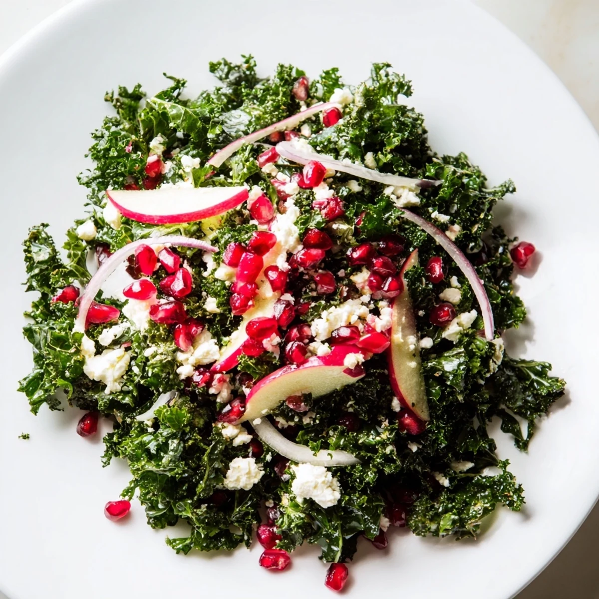 A close-up view of a healthy Winter Kale Salad with Pomegranate, ready to enjoy with a tangy, lively flavor.