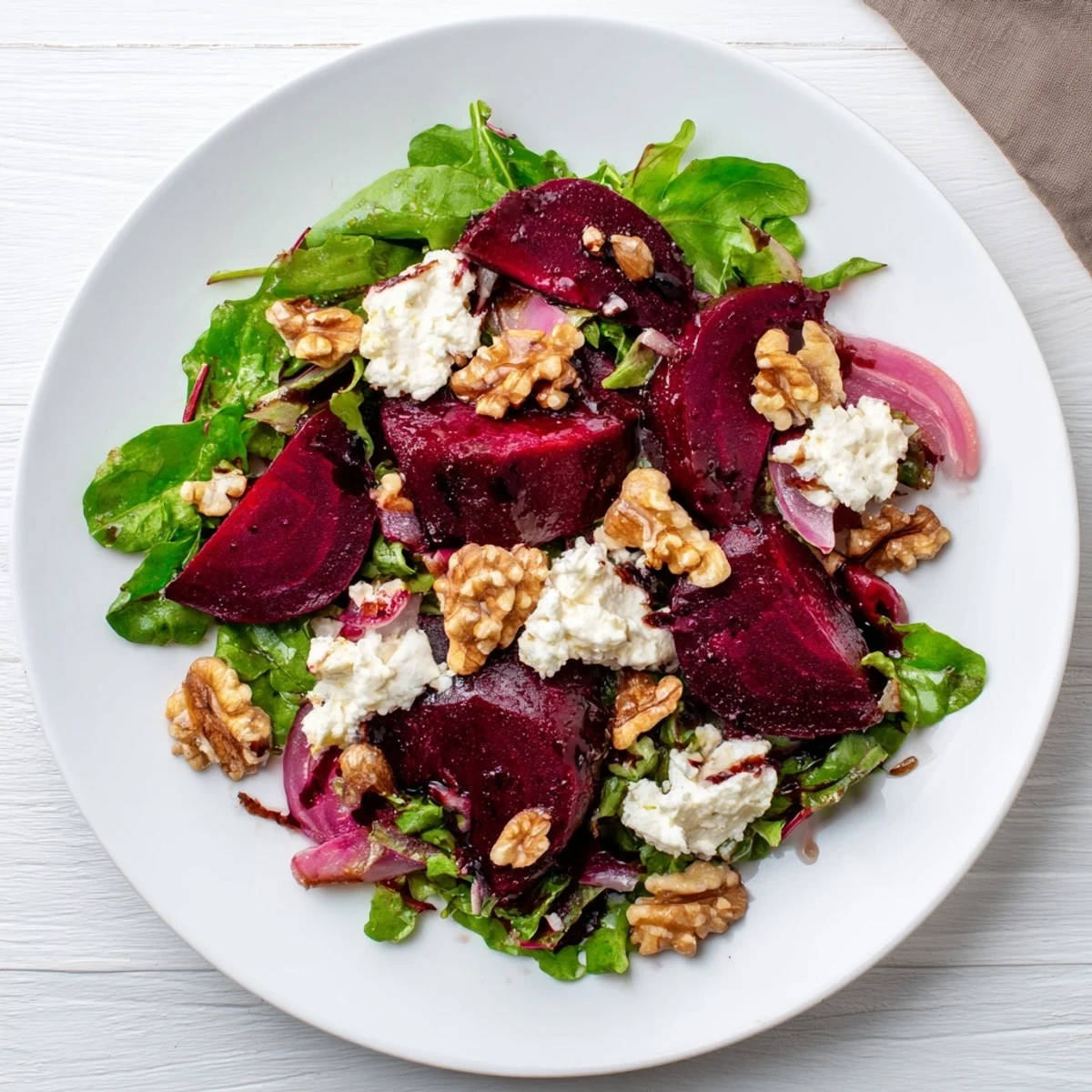 Vibrant roasted beet and goat cheese salad with crumbled cheese and toasted walnuts.