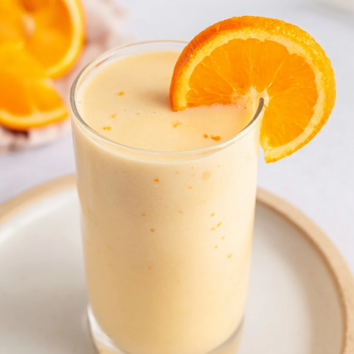 Enjoy a refreshing orange smoothie, a cold and sweet drink, perfect for a sunny day.
