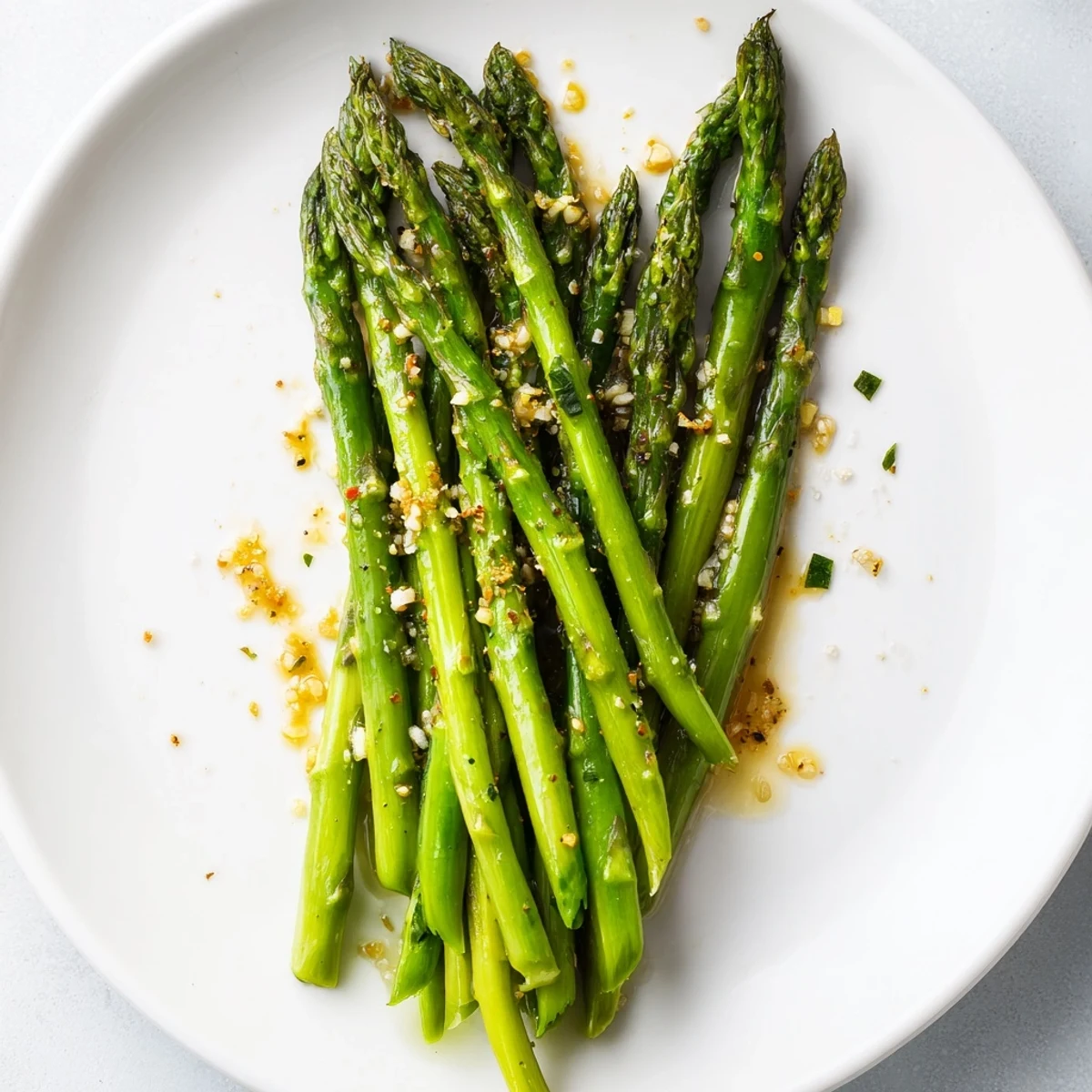 Freshly cooked Garlic Asparagus, tender-crisp in a skillet, seasoned with black pepper and salt.