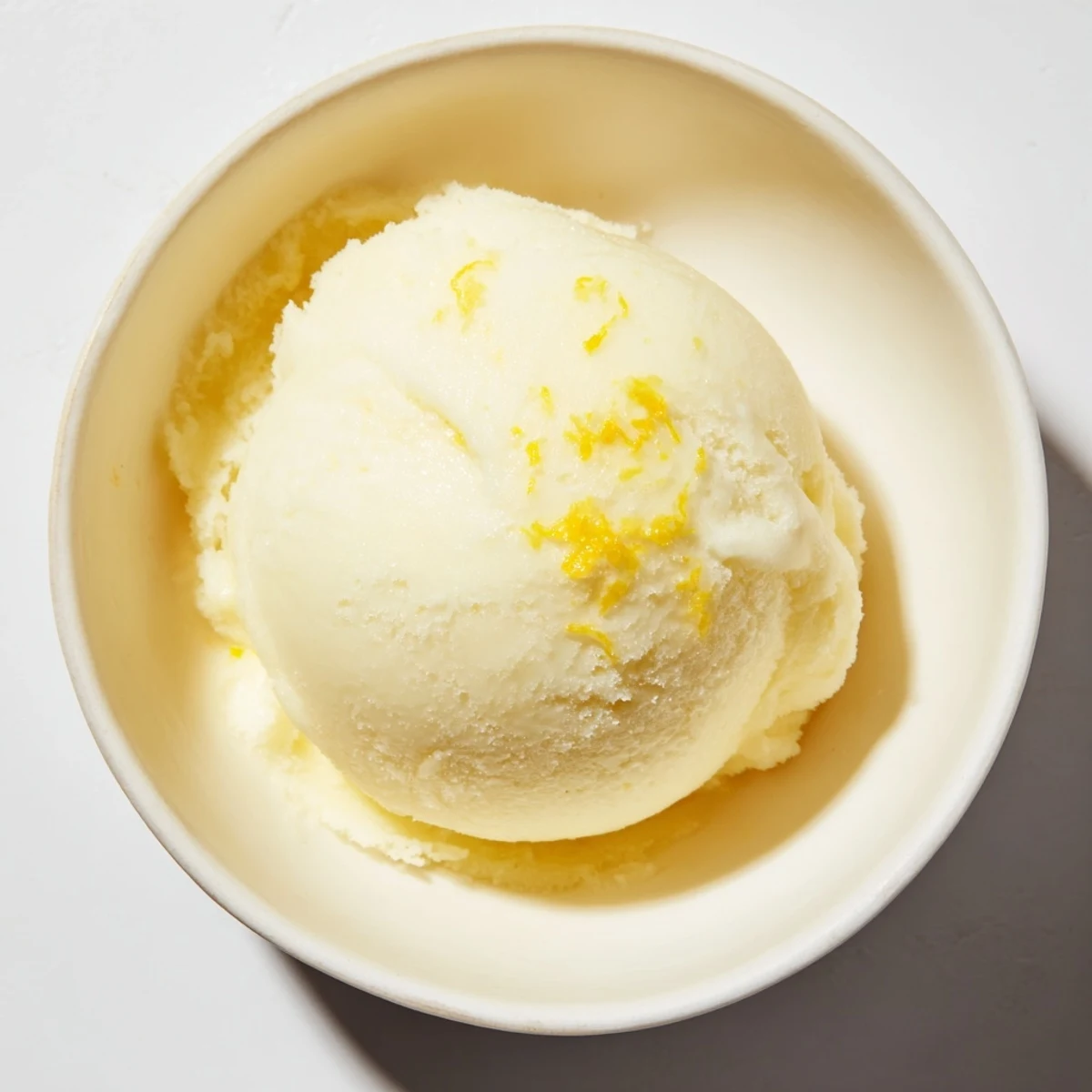 Freshly churned lemon sorbet, a refreshing frozen treat, ready for a warm afternoon.