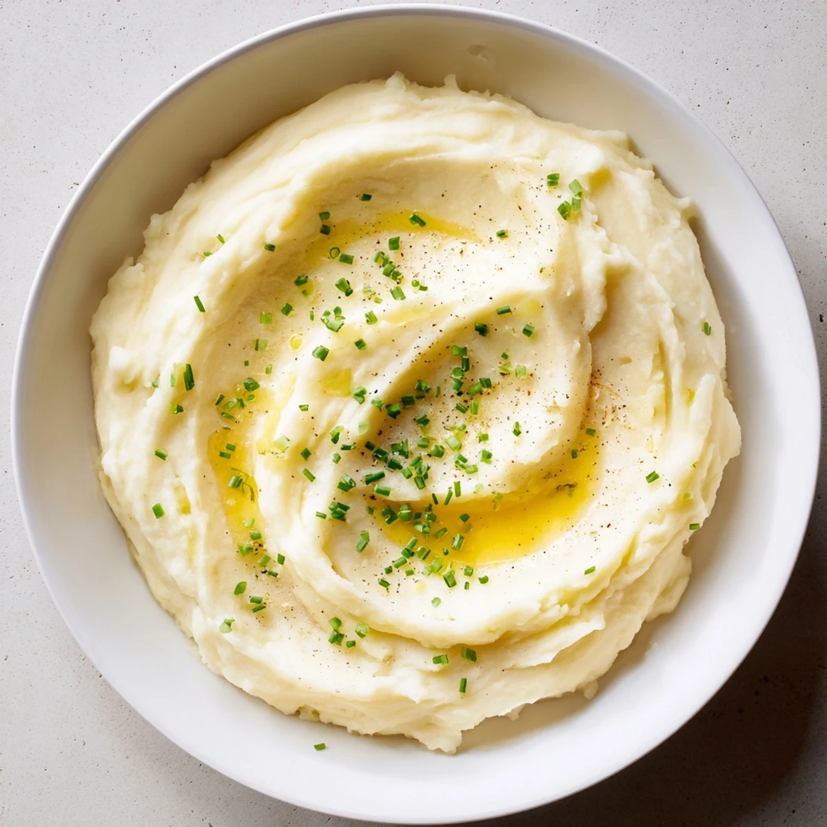 Fluffy Creamy Mashed Potatoes, steaming hot, ready to be scooped and enjoyed with gravy.