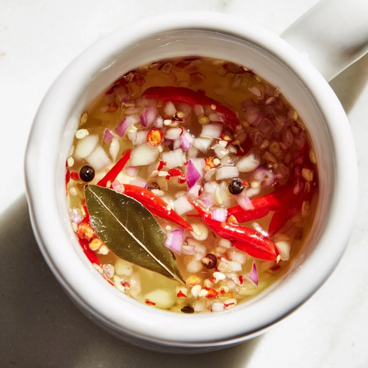 This delicious Spiced Vinegar Sauce features visible garlic, onions, and peppercorns, infused with tangy vinegar goodness.