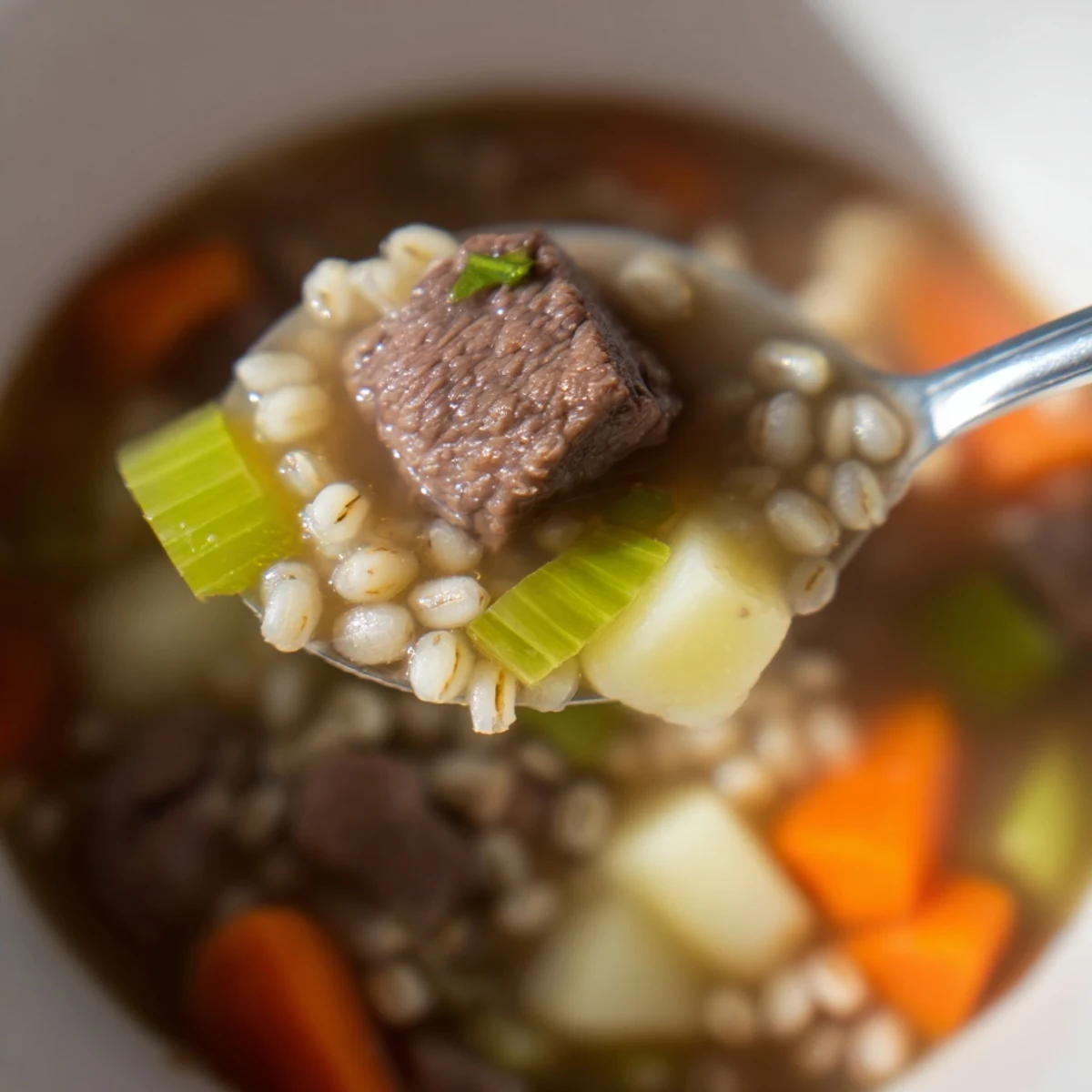 Steaming bowl of Beef Soup with Barley, loaded with tender beef, carrots, and potatoes in a rich broth.