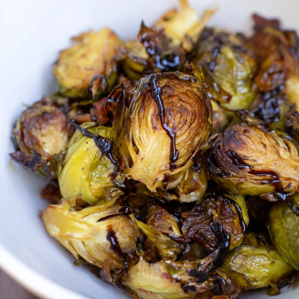 Fork-tender roasted Brussels sprouts with smoky turkey bacon, served warm with a fresh lemon wedge garnish.