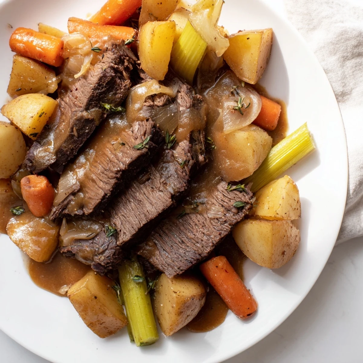 Family-style platter of Slow Cooker Pot Roast with Savory Gravy, drizzled over shredded beef and roasted vegetables.