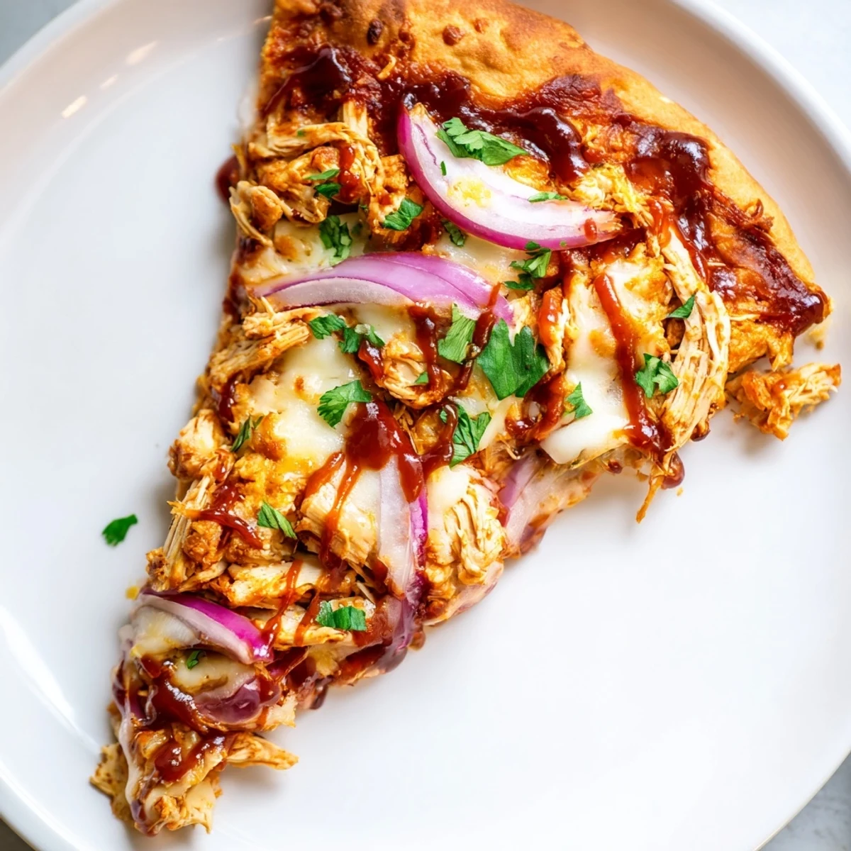 Slices of BBQ Chicken Pizza with Red Onion showcase tender chicken, sweet red onion slices, and a drizzle of tangy barbecue sauce.