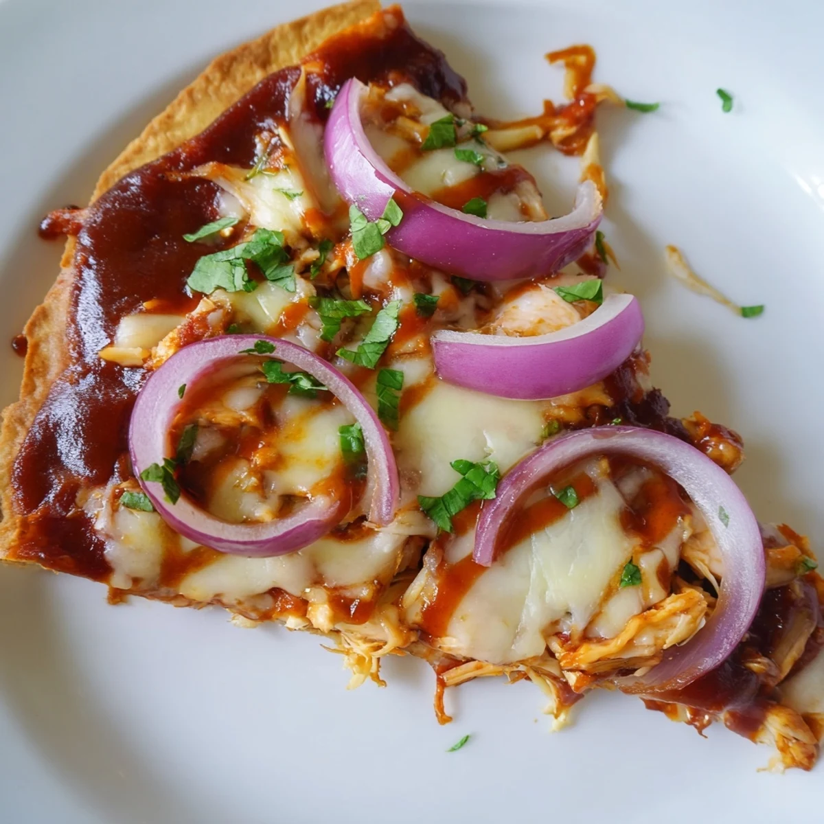 A rustic BBQ Chicken Pizza with Red Onion topped with fresh cilantro, served on a checkered board for a casual dinner.