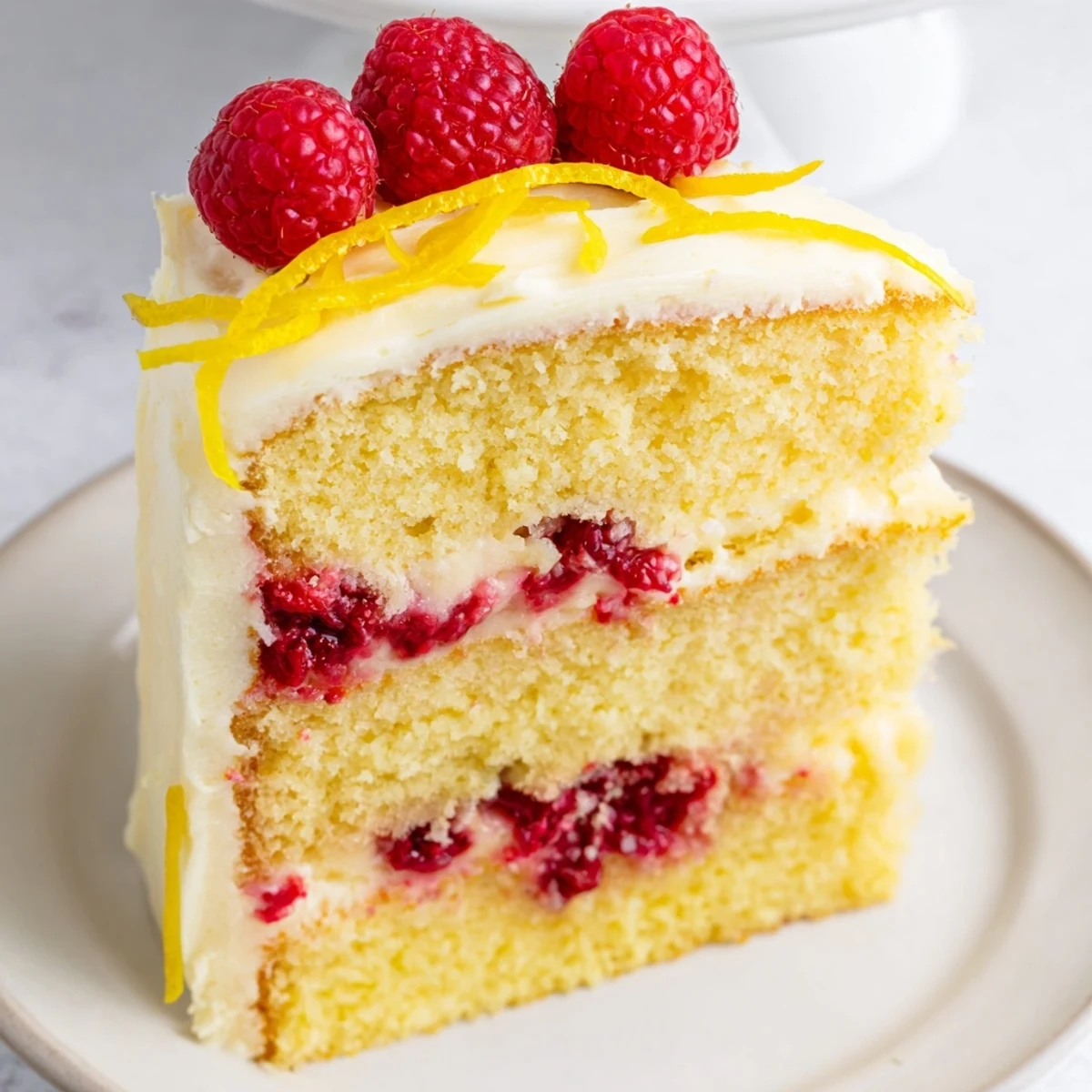Moist layers of the Lemon Raspberry Layer Cake with Frosting showcase vibrant raspberry filling and tangy lemon cream cheese frosting.