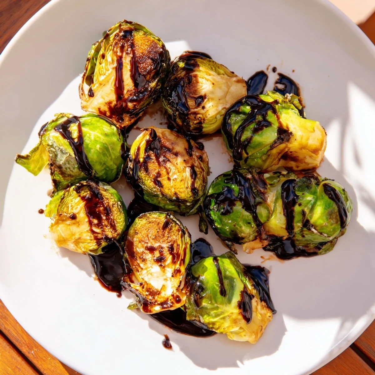 Freshly roasted Brussels sprouts with balsamic glaze are served warm, their caramelized leaves glistening beside a fork for an easy side dish.