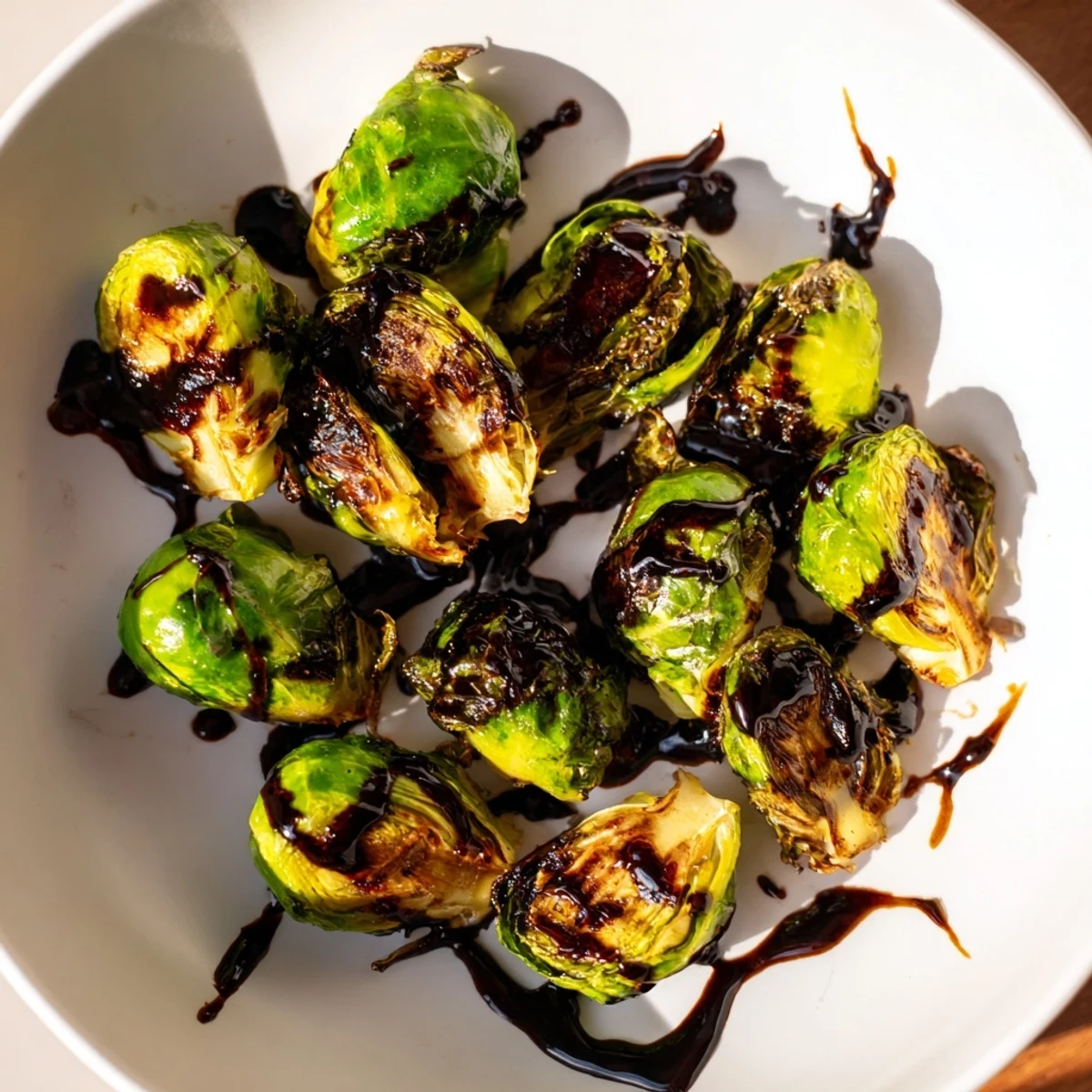 Crispy, caramelized Brussels sprouts with balsamic glaze sit on a platter, a glossy drizzle highlighting their savory-sweet aroma for dinner tonight.