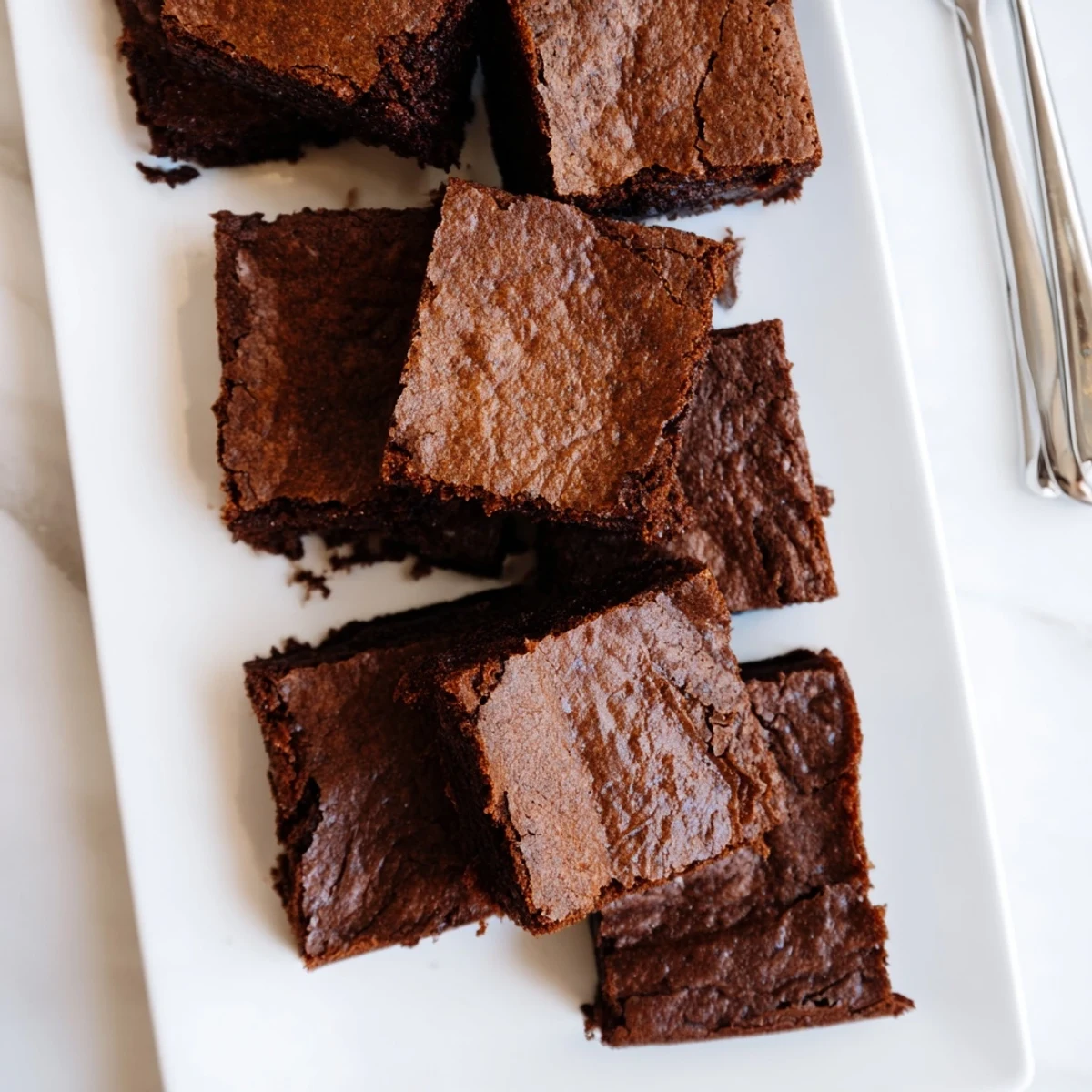 A close-up of Fudgy Brown Butter Mochi Brownies cut into squares with a gooey texture and deep chocolate color.
