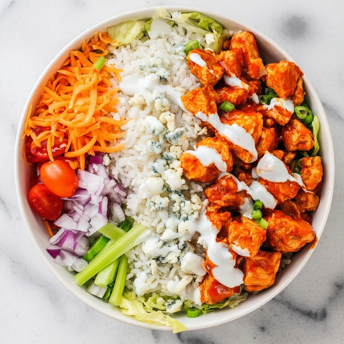 Festively arranged Buffalo Chicken Bowls showcase spicy chicken, cool ranch drizzle, and colorful veggies over fluffy rice.