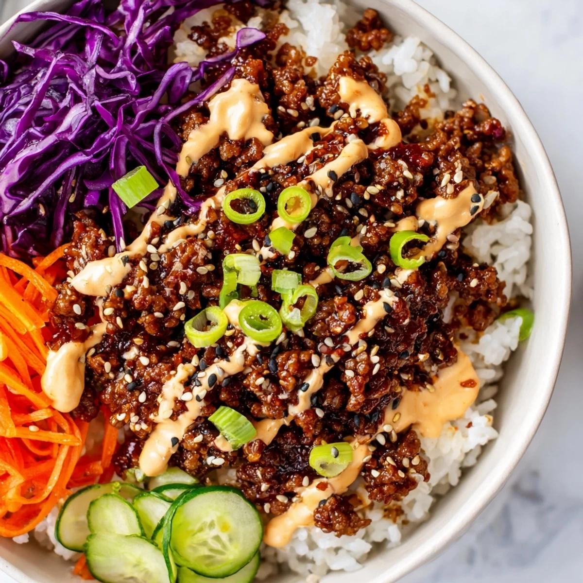 A vibrant serving suggestion for Korean Beef Bowl with Spicy Mayo, highlighting the saucy beef, shredded carrots, and cucumber slices on a warm, inviting dinner table.