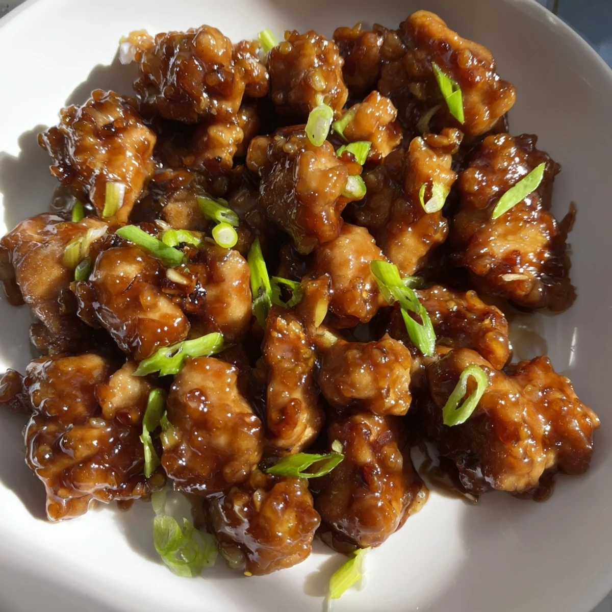 Golden brown Mongolian chicken pieces glazed in shiny sweet and savory sauce