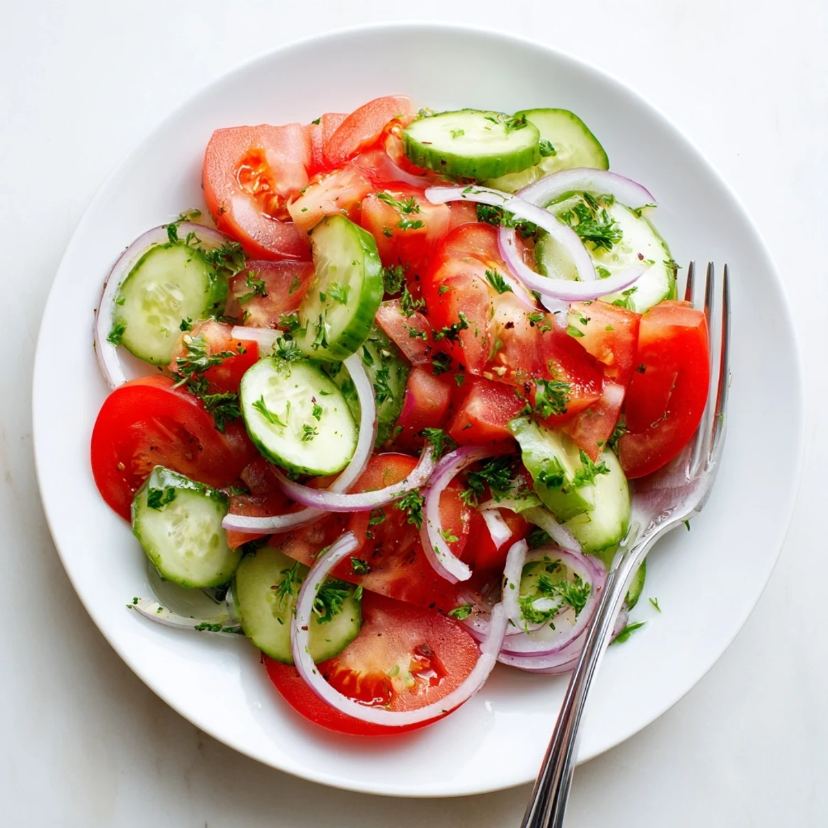 Fresh tomato, cucumber, and onion salad tossed in light vinaigrette with chopped parsley garnish