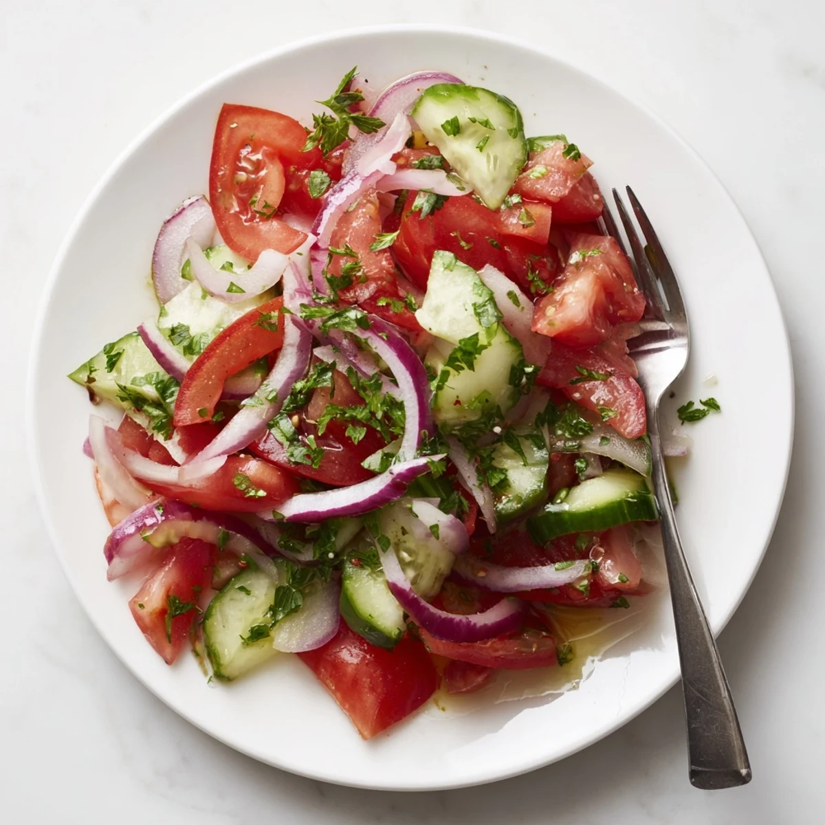Crisp tomato, cucumber, and onion salad featuring vibrant red and green vegetables in a bowl