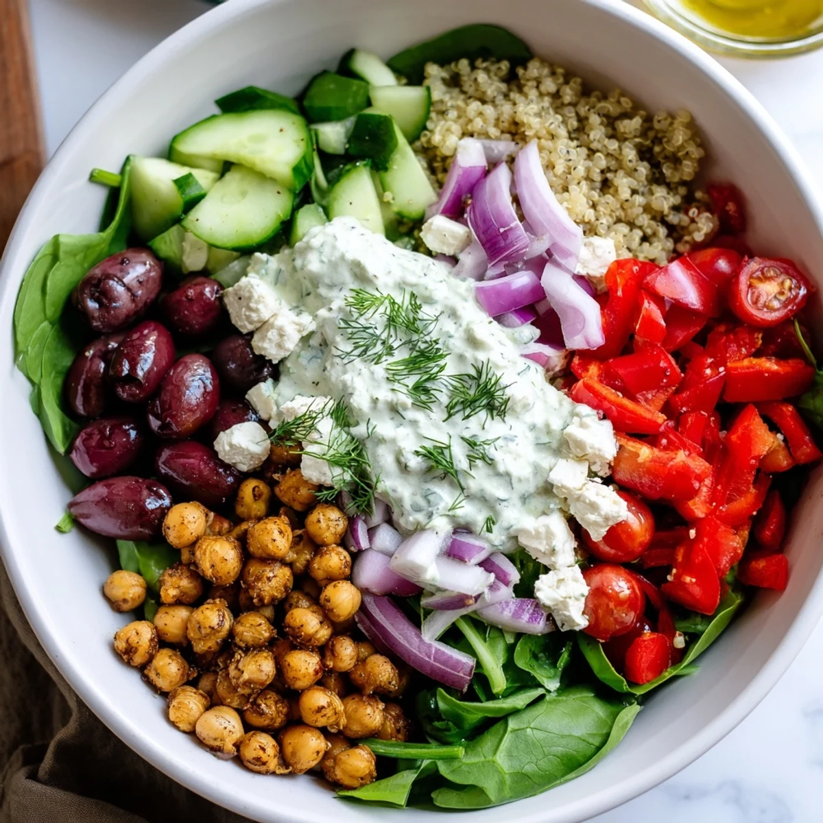 Healthy Greek Power Bowls featuring roasted chickpeas, crisp veggies, feta cheese, and lemon wedges