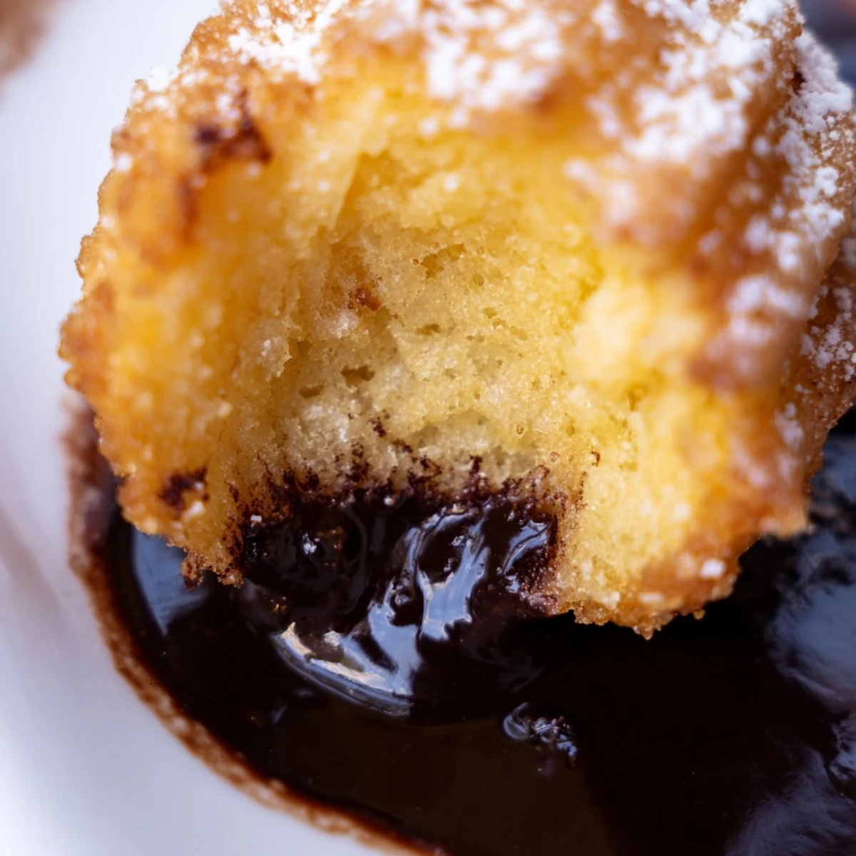 Freshly fried deep fried marshmallows showing golden batter and soft white interior