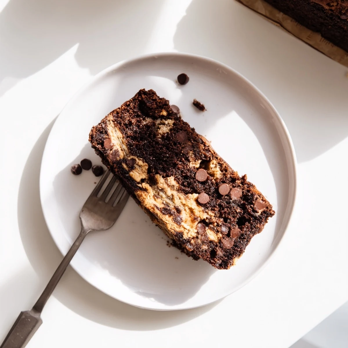 Sliced chocolate peanut butter banana bread displaying moist crumbs and melted chocolate chips on a wooden board