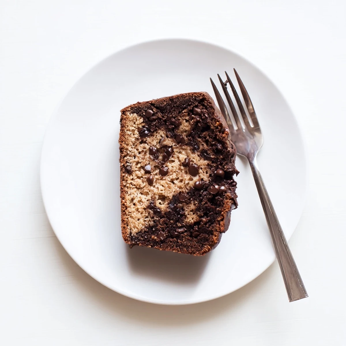 Freshly baked chocolate peanut butter banana bread loaf with golden peanut butter swirl on top
