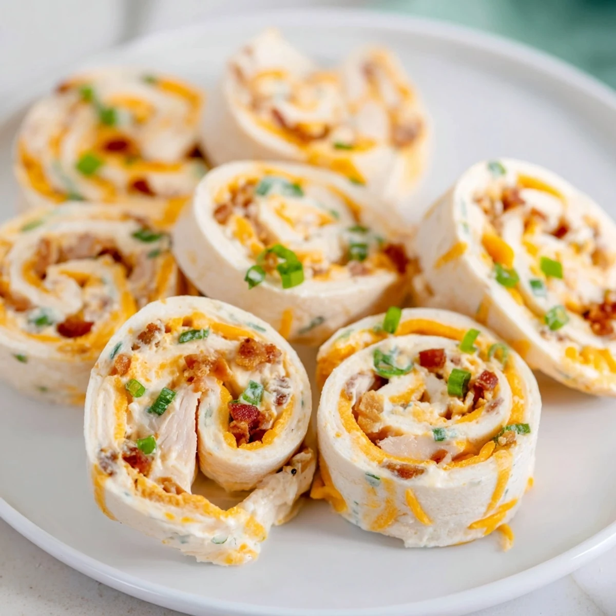 Creamy chicken and bacon crack chicken pinwheels arranged on a serving platter