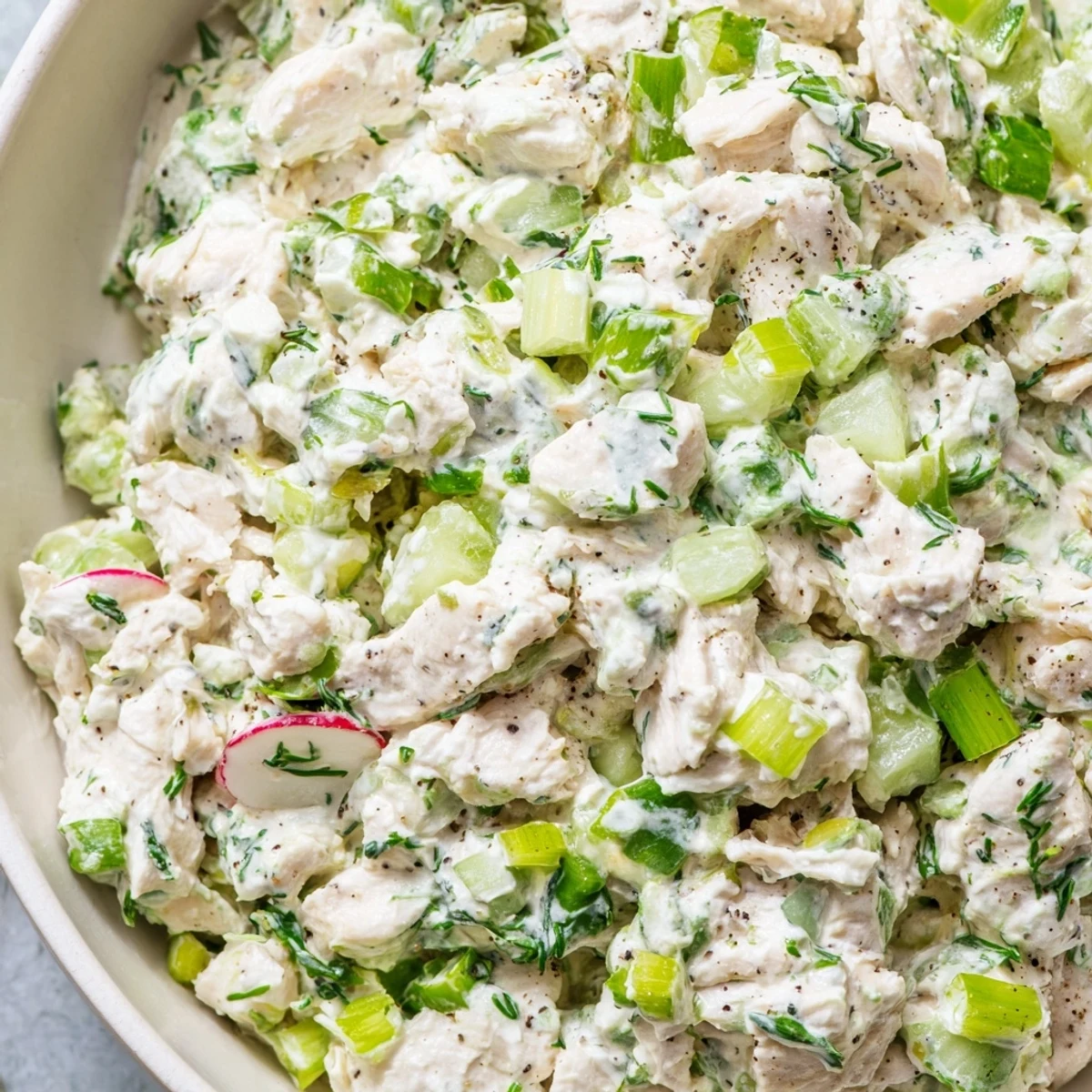 Hearty green goddess chicken salad dip garnished with radishes alongside crisp crackers for dipping