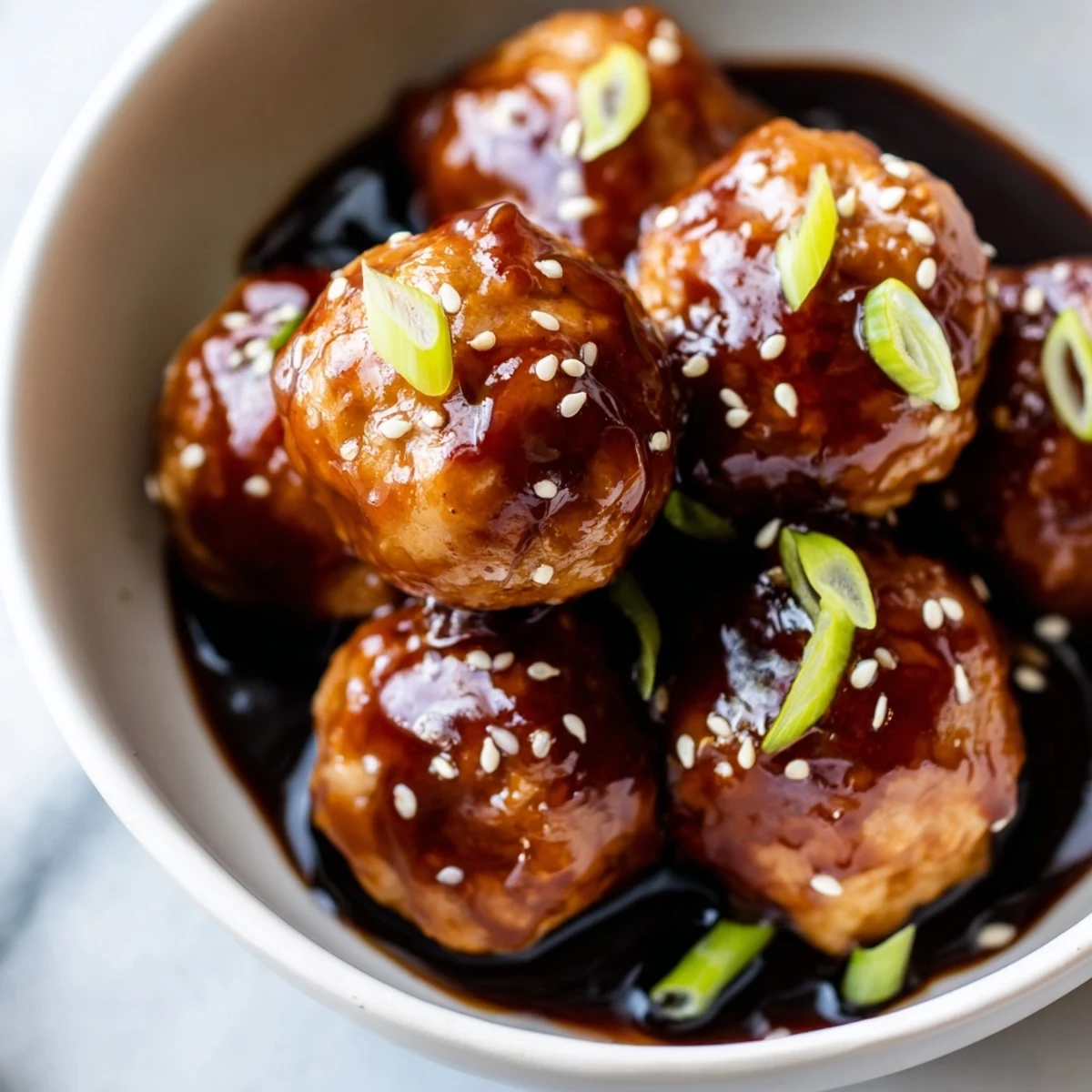 Perfectly browned ground chicken meatballs tossed in sticky homemade teriyaki sauce topped with fresh green onions