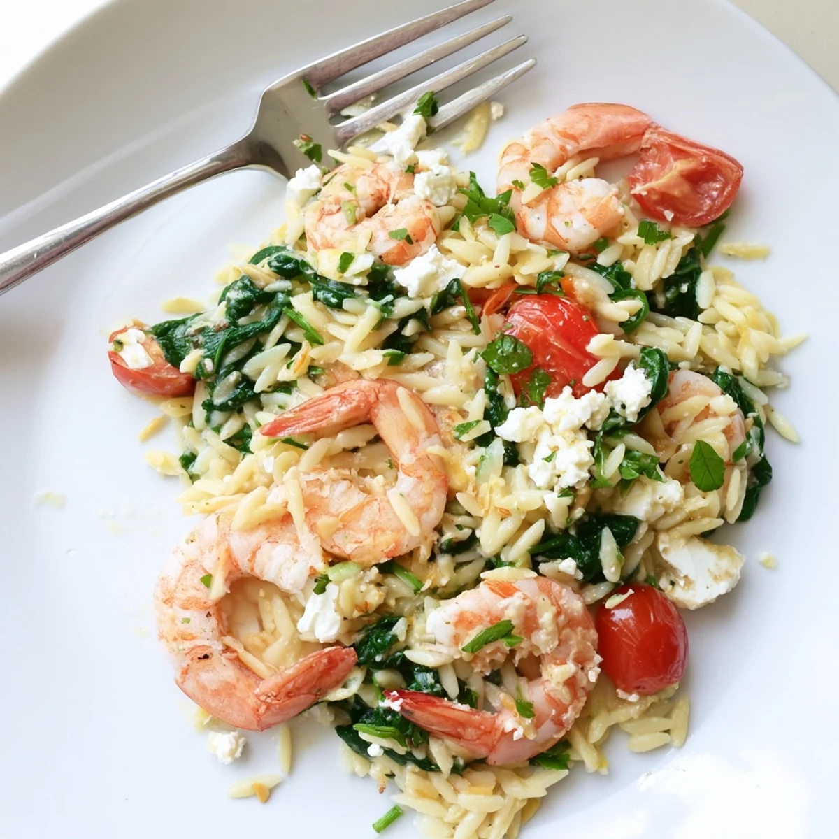 Creamy Lemon Feta Orzo Shrimp plated with zesty lemon wedges and vibrant green spinach