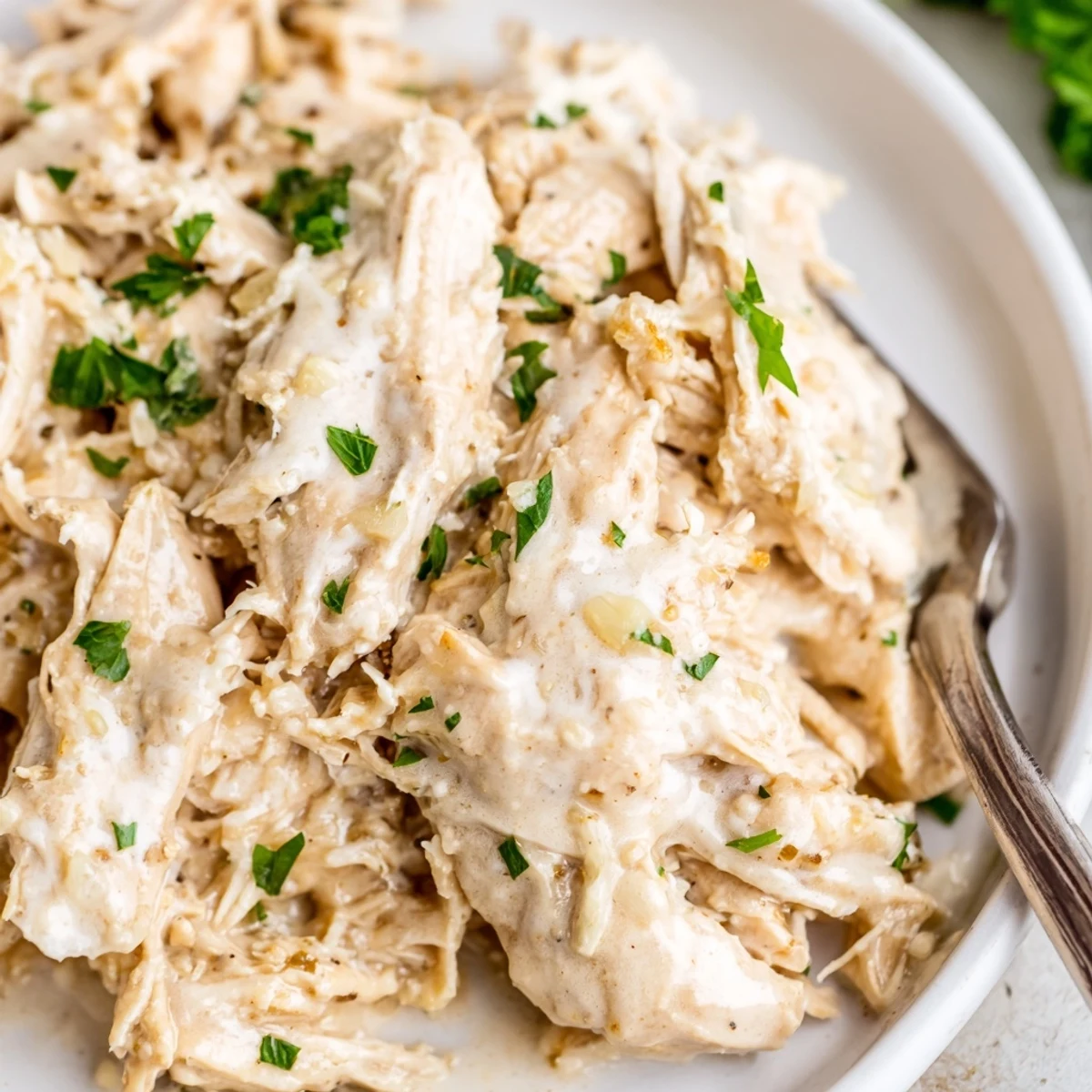 Golden chicken breasts swimming in a rich creamy garlic Parmesan sauce with fresh parsley garnish