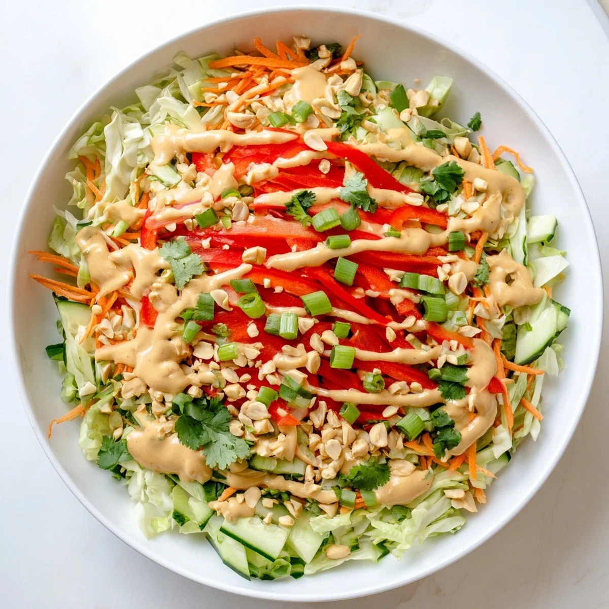 Colorful Thai salad peanut sauce featuring crisp vegetables drizzled with creamy peanut dressing and crunchy peanuts