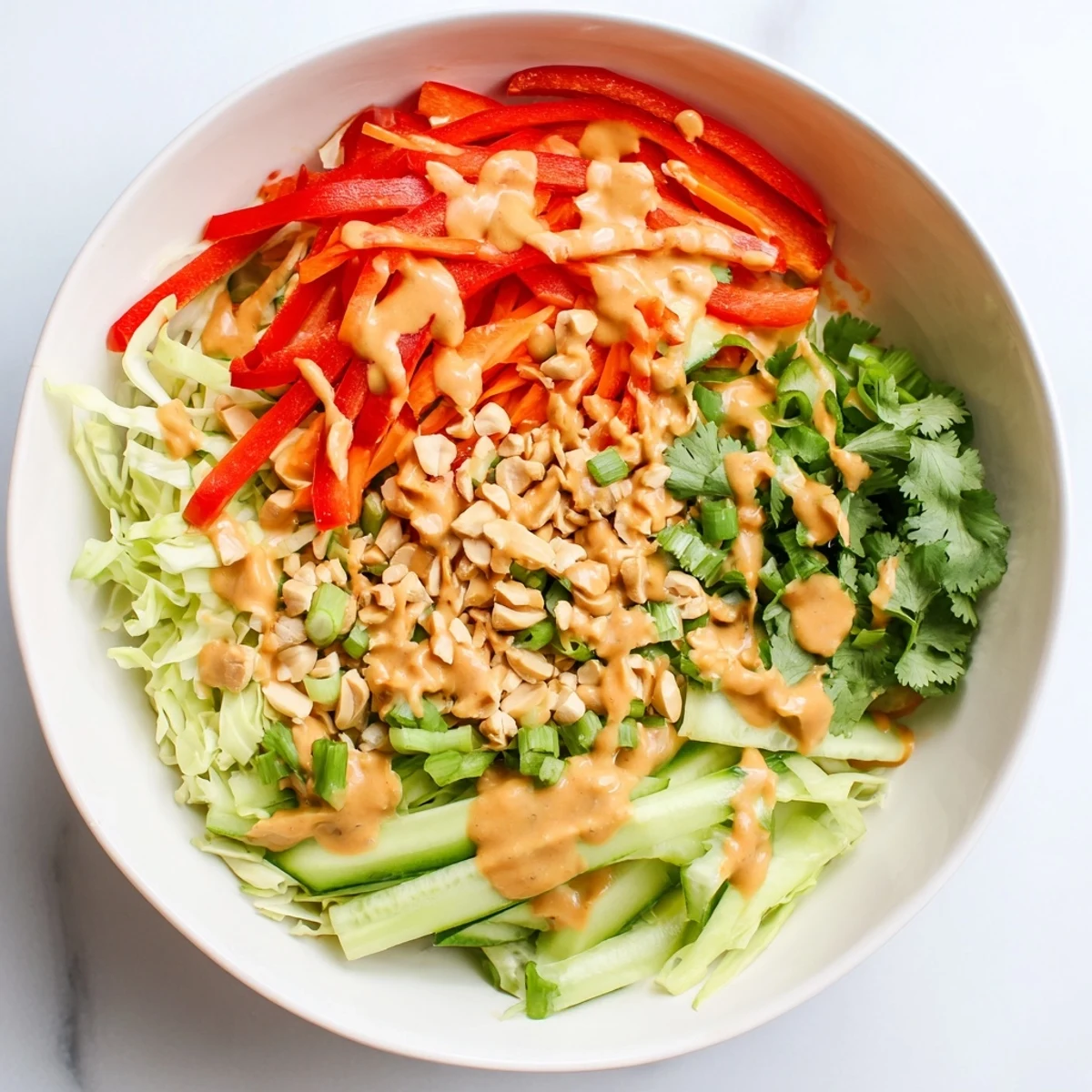 Vibrant Thai salad peanut sauce bowl topped with chopped roasted peanuts and fresh cilantro garnish
