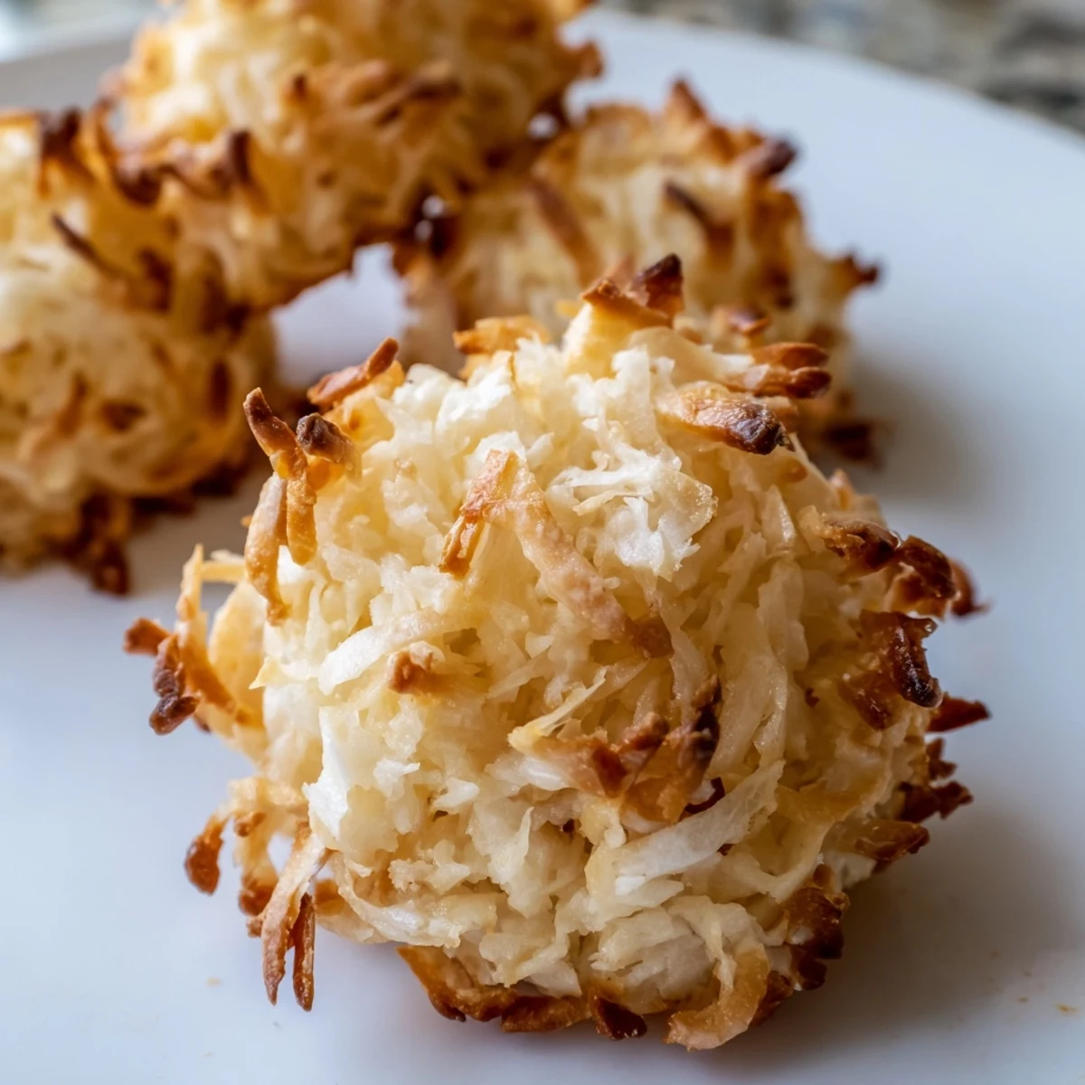 Chewy coconut macaroons with golden toasted tops arranged on parchment paper