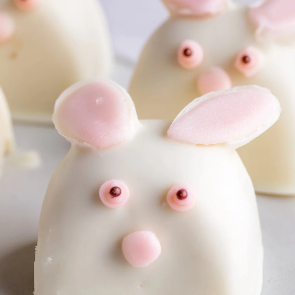 Creamy white chocolate bunny cakesicles decorated with sprinkles for a fun Easter dessert