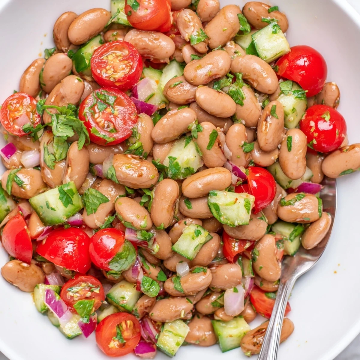 Hearty pinto bean salad served in a rustic bowl garnished with vibrant red bell peppers