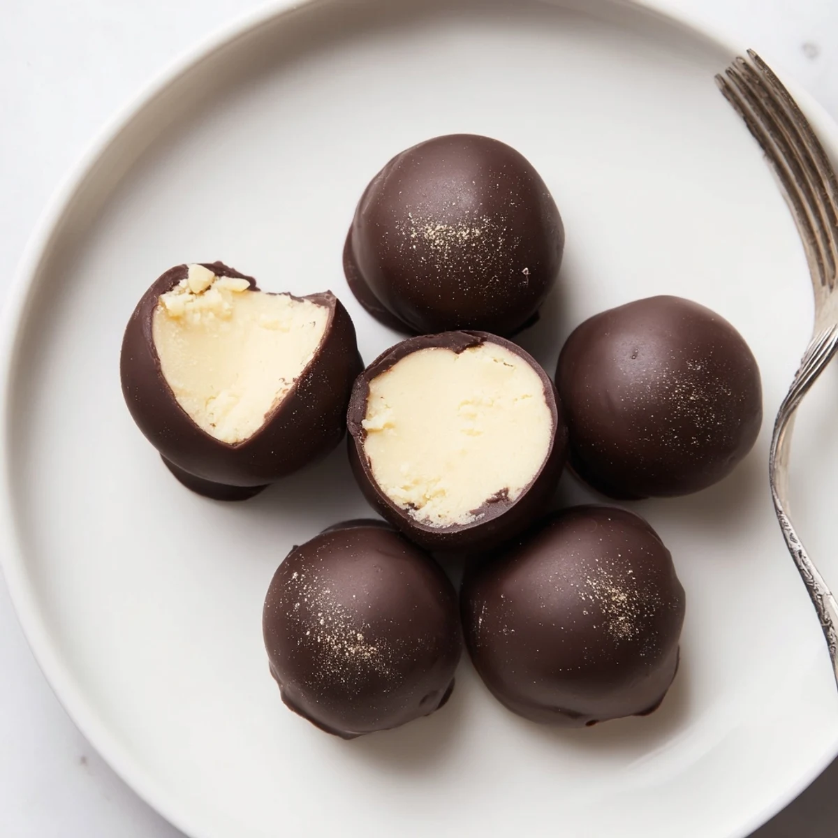 Dark Chocolate Eggnog Truffles glistening with shiny shells, dusted nutmeg, holiday platter