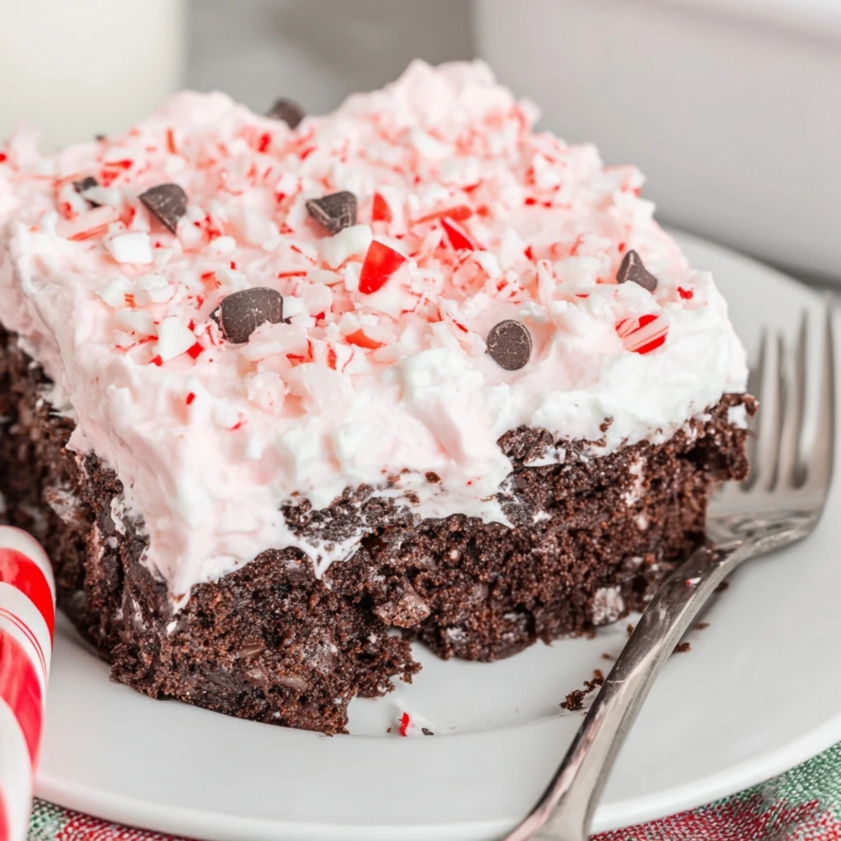 Sliced Peppermint Poke Cake showing pudding-soaked holes and minty chocolate cake layers