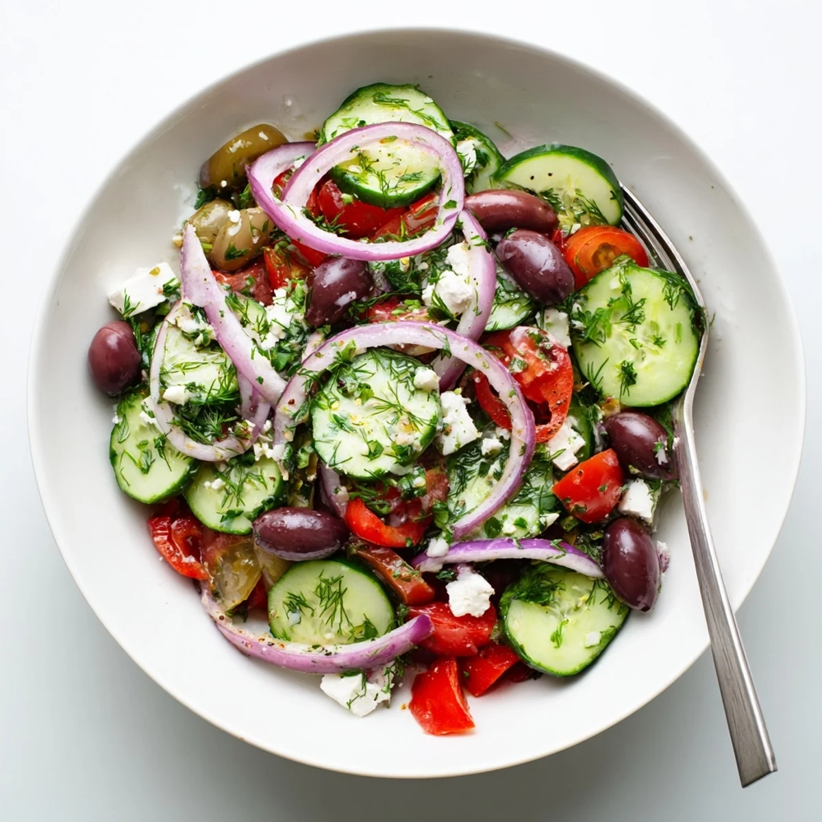 Fresh Mediterranean cucumber salad with crisp vegetables, tangy feta cheese, and bright herbs in a serving bowl