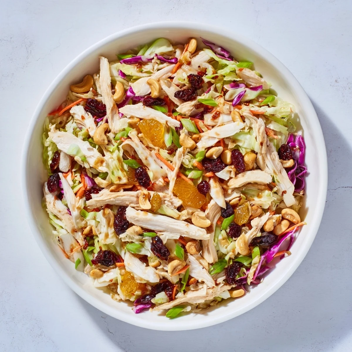 Colorful Asian chicken cranberry salad bowl with crunchy cabbage and sweet orange segments
