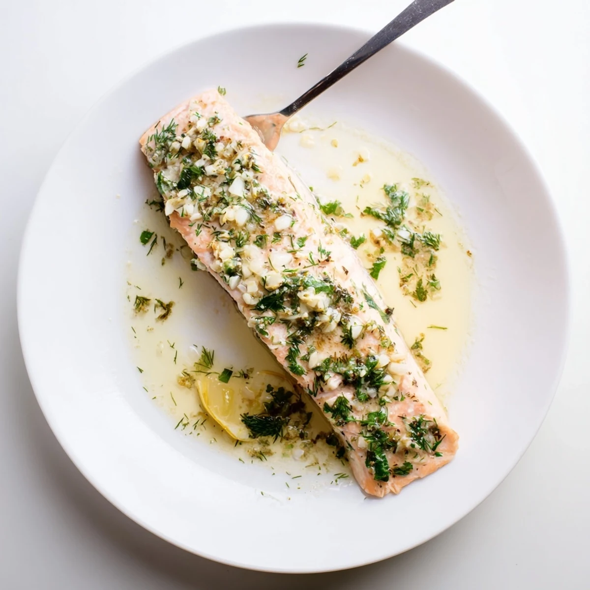 Warm Garlic Butter Ghee Salmon Bake topped with lemon wedges and parsley