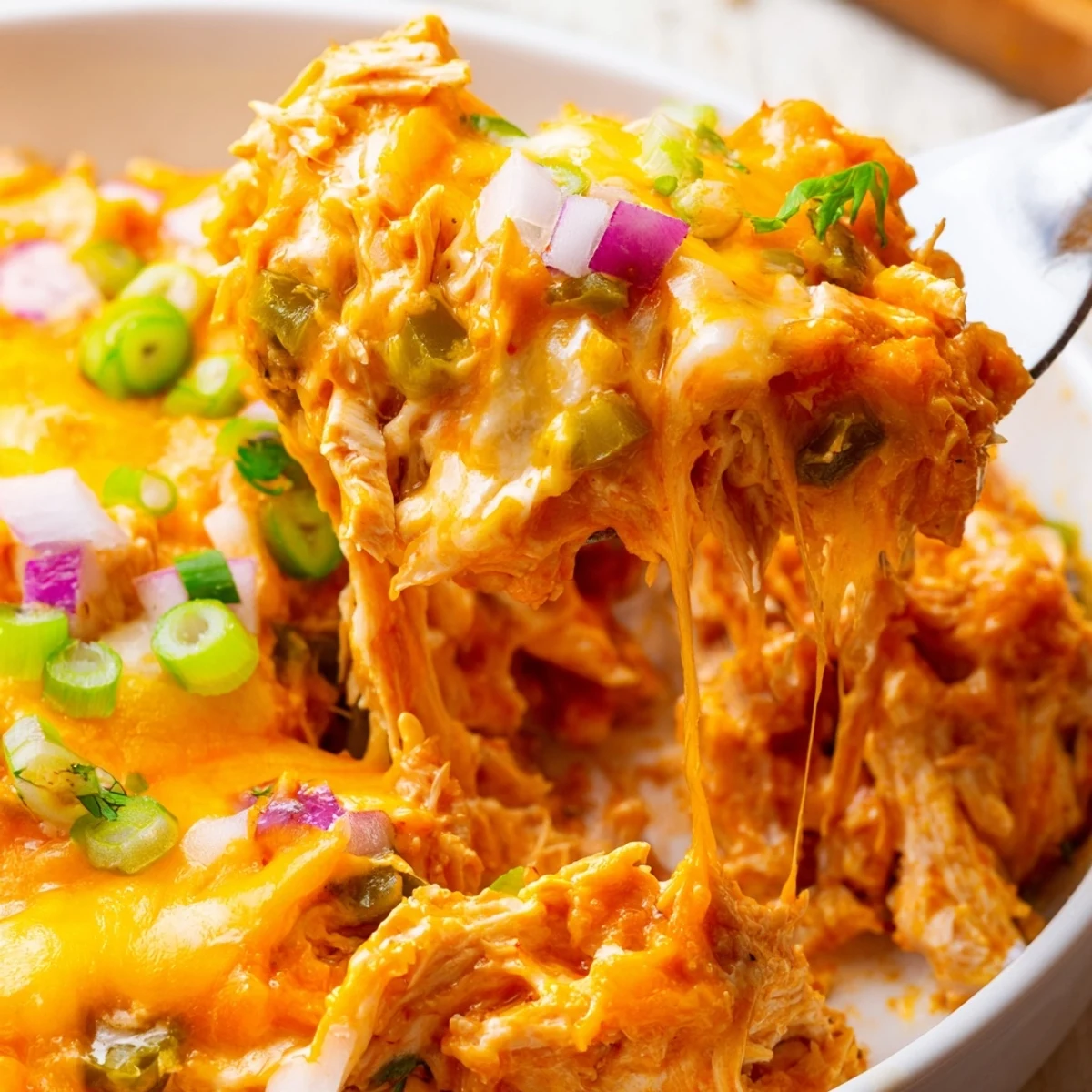 Bubbly jalapeno buffalo chicken casserole with melted golden cheese and fresh cilantro garnish