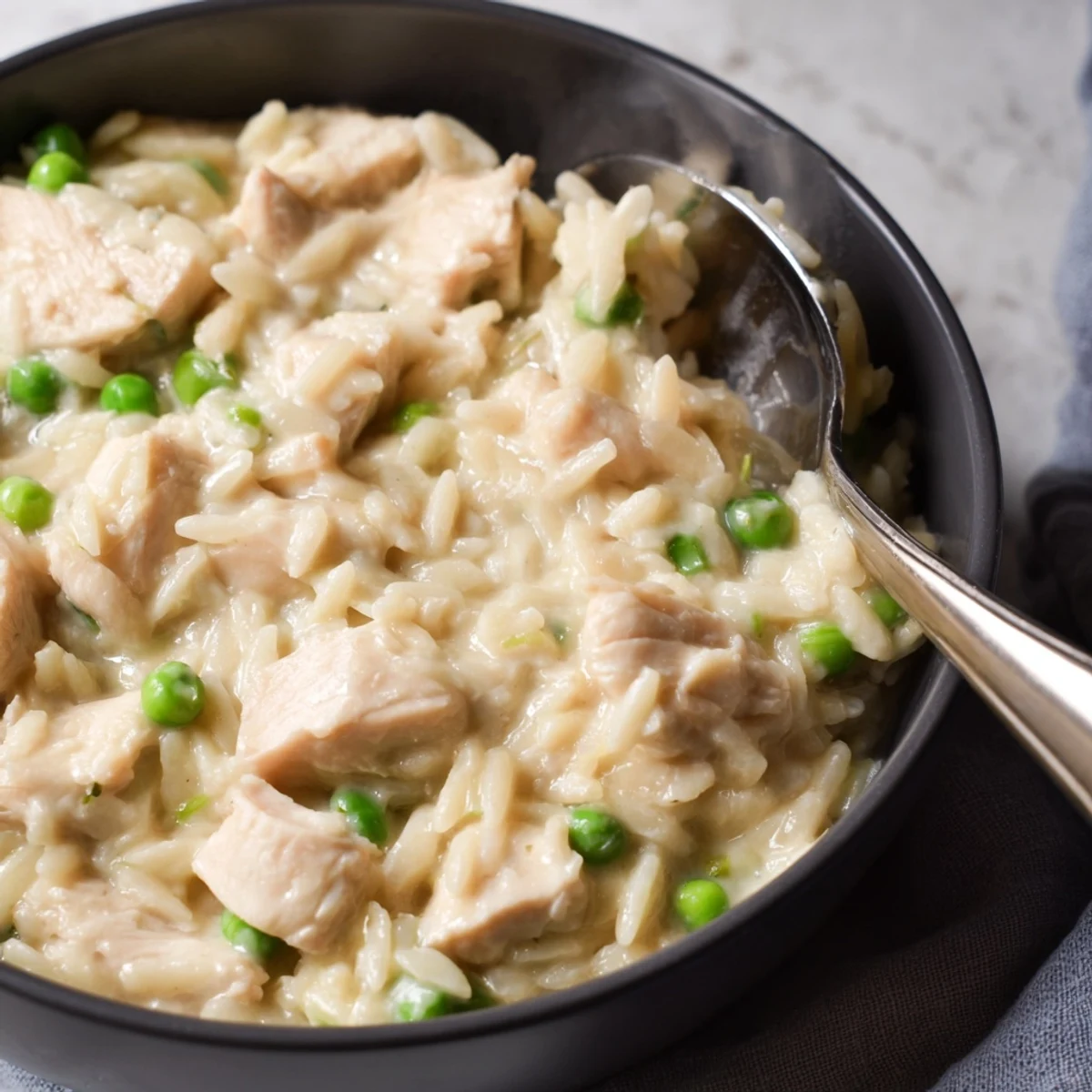 Steaming bowl of chicken pot pie orzo topped with fresh parsley, showcasing a velvety texture and hearty vegetables