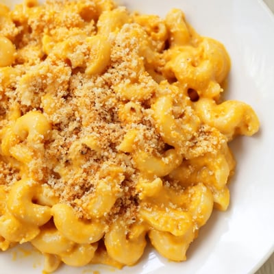 Steam rises from a warm bowl of Vegan Butternut Squash Mac and Cheese topped with golden, crispy breadcrumbs.