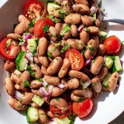 Creamy tender pinto beans mixed with diced tomatoes cucumber and zesty cilantro dressing