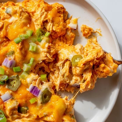 Creamy jalapeno buffalo chicken casserole served steaming in a rustic baking dish