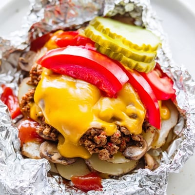 Golden campfire hobo packets filled with juicy ground beef and melted cheddar cheese